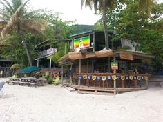 a bar on the beach with people sitting at it