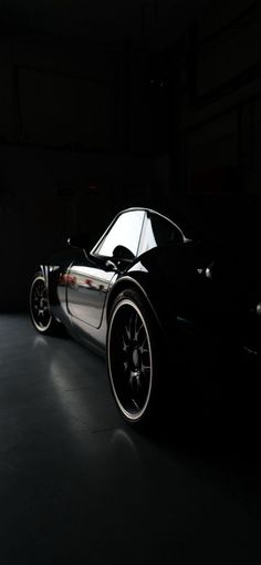 a black sports car is parked in the dark