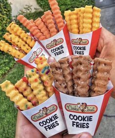 a person holding six cones of cookies and pretzels in their hands with the words cookie fries written on them