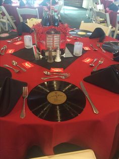 a red table topped with a record and silverware