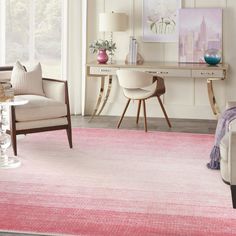 a living room filled with furniture and a pink rug