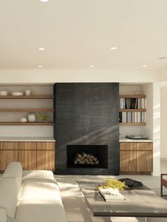 a modern living room with a fireplace and bookshelves