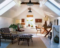 an attic living room with white walls and wood floors