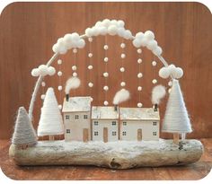 a white house with trees and snow on the roof is made out of driftwood