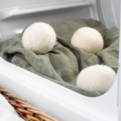 two white pom poms sitting on top of a blanket in an open refrigerator