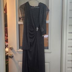 a black dress is hanging on a door