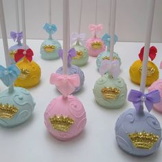 there are many different colored candies with bows on the top one is pink, blue, yellow and white