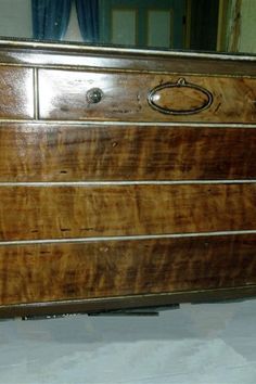 an old dresser with wooden drawers and knobs