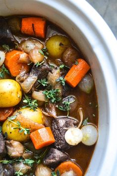 a white bowl filled with stew and vegetables