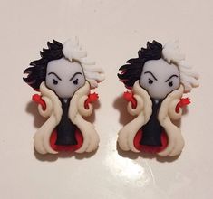 two white and black ear clips with red accents on top of a white countertop