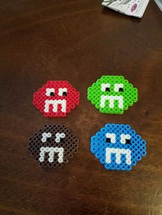 four perler beads sitting on top of a wooden table