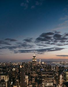 the city skyline is lit up at night, with skyscrapers in the foreground