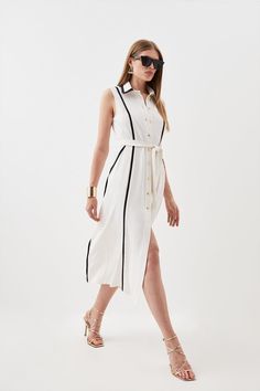 Feel Confident In Our Midi Dress, With A Shirt Style Design Featuring A Formal Collar, As Well As A Belted Waist For A Cinched Silhouette, And A Long, Flared Skirt. Style It With Block Heels Or Ankle Boots For A Look Perfect For Office Days, Then Wear It With Heeled Boots Or Strappy Heels For An Evening Look. Soft Tailored Pipe Detail Sleeveless Shirt Dress Flattering Fit And Flare Silhouette Unique Contrasting Lining V Neckline Formal Collar Detailing Belted Waist Feature Relaxed, Flared Skirt