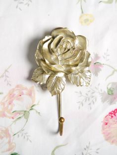 a gold rose on a white background with pink and yellow flowers