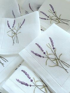 four lavender embroidered napkins on top of each other