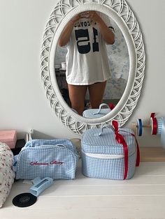 a woman taking a selfie in front of a mirror with clothes on the floor