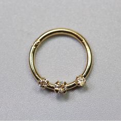 a gold ring with three small flowers on the side and two smaller flowers on the inside