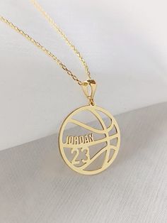 a gold plated necklace with the word jordan on it and a basketball ball in the center