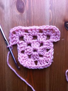 a crocheted object is sitting on a wooden surface