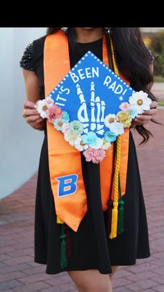 a woman wearing an orange and blue graduation cap with the words it's been paid