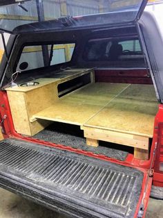 the back end of a pickup truck with an open hatchback door and storage compartment