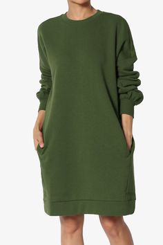 a woman wearing a green dress with long sleeves