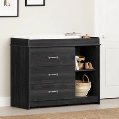 a black dresser with three drawers and baskets