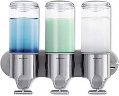 three glass containers with different colored liquids in them on a metal wall mounted holder for soap and toothbrushes