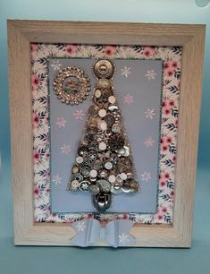 a christmas tree made out of buttons in a frame