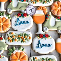 decorated cookies are arranged on a table with name tags and oranges in the background