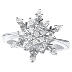 a snowflake ring with diamonds on it's sides and the center surrounded by smaller white stones