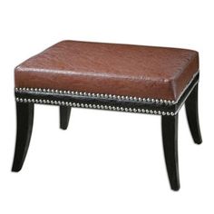 a brown leather bench with studded trimmings on the legs and foot rest