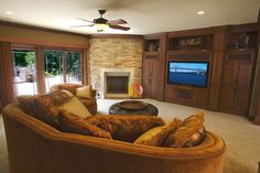 a large living room with couches and a flat screen tv mounted on the wall