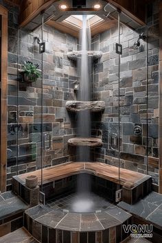 A rustic stone shower featuring a natural waterfall, intricate stonework, wooden accents, and lush greenery, creating a serene and luxurious spa-like experience. Rock Waterfall Shower Master Bath, Walkin Shower With Bathtub, River Rock Shower Ideas, Waterfall Shower Bathroom, Garage Sauna, Rock Shower Ideas, Stone Bathroom Ideas, Stone Shower Ideas, Basement Spa