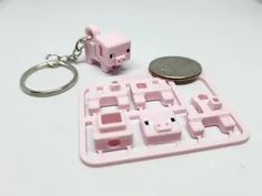 a keychain that has a pig on it and a coin sitting next to it