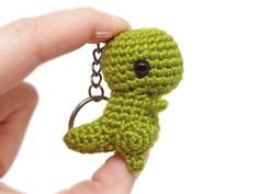 a small green crocheted keychain with a tiny stuffed animal on it