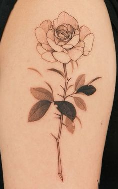 a black and white rose tattoo on the back of a woman's right arm