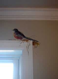 a bird sitting on top of a window sill next to a white door frame