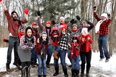 a group of people standing on top of a snow covered ground next to trees in the woods