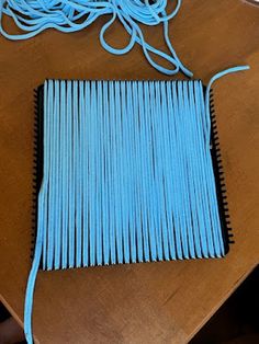 a wooden table topped with lots of blue yarn