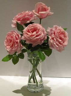 some pink roses are in a clear vase