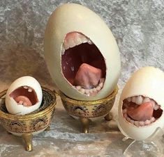 an egg with its mouth open next to two smaller eggs that have their mouths open