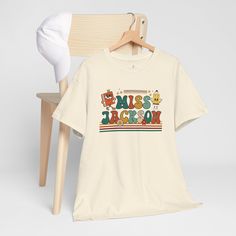 a white t - shirt with the words miss you next to a wooden chair