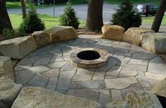 an outdoor fire pit surrounded by large rocks