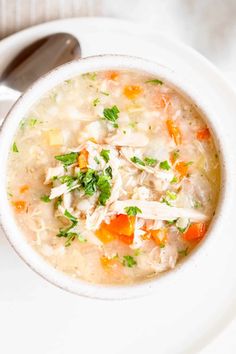 a white bowl filled with chicken and vegetable soup