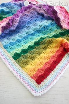 a multicolored crocheted dishcloth on a white table