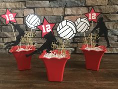 three cupcakes in red cups with volleyball decorations