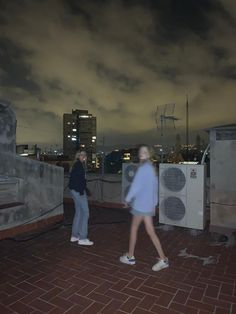 two people walking on a roof at night