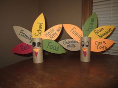 three toilet paper roll turkeys sitting on top of a wooden table