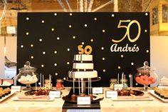 a table topped with cakes and desserts on top of it next to a sign that says 50